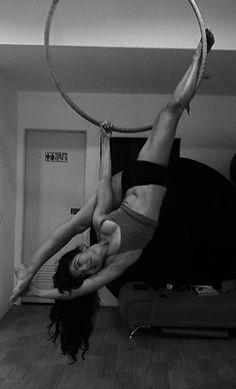 a woman is doing aerial acrobatics with a hoop