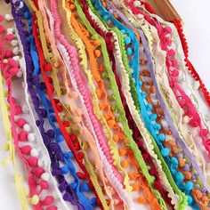 multicolored crochet bracelets with wooden sticks on white background, closeup