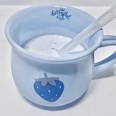 a blue cup filled with milk and a spoon