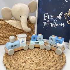 a wooden toy train set sitting on top of a wicker basket next to a book