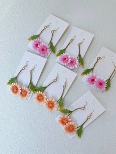 six flower earrings with dangling hooks are shown in pink and orange flowers on white cards