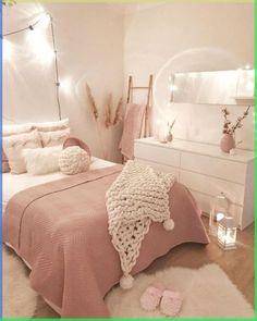 a bedroom with white furniture and pink blankets on the bedspread is decorated with lights