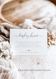 a white business card sitting on top of a pile of fabric and cloth next to a wooden cutting board