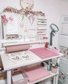 a craft room with lots of crafting supplies on the desk and shelves above it