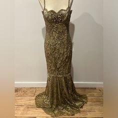 a mannequin wearing a gold dress with sequins on the bottom and back