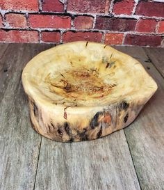 a piece of wood sitting on top of a wooden floor next to a brick wall