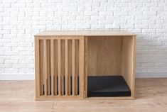 a wooden crate with a black cushion in front of a white brick wall and wood floor