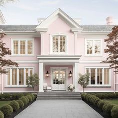 a large pink house with white trim and two story windows on the second floor is shown