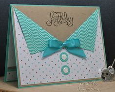 a close up of a birthday card with a bow on the front, and a button in the middle