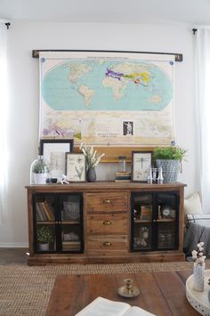 a living room with a large map on the wall and wooden furniture in front of it