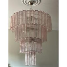 a pink chandelier hanging from the ceiling in a room with a light fixture