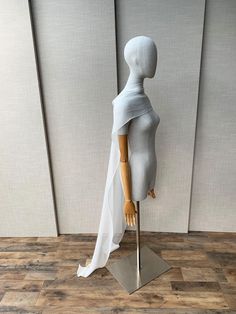 a mannequin with white fabric draped over it