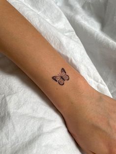 a woman's foot with a small butterfly tattoo on the left side of her arm