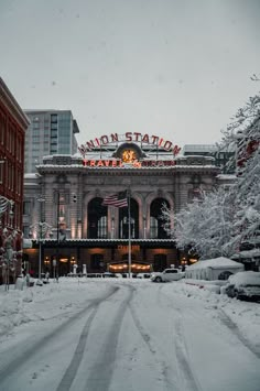 the union station in winter with snow on the ground and buildings around it, all lit up