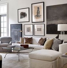 a living room filled with lots of furniture and pictures on the wall above it's coffee table