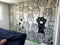 a black and white drawing on the wall of a room with a blue couch in front of it