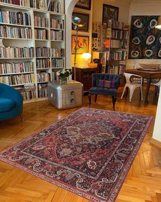 a living room filled with furniture and bookshelves full of bookcases next to a blue chair