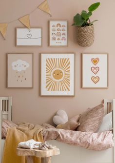 a child's bedroom with pink walls and pictures on the wall