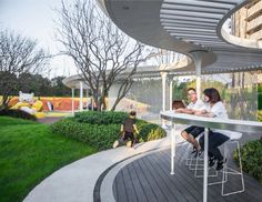 two people sitting at a table in the middle of a park