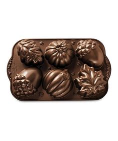 a chocolate mold that is shaped like pumpkins and acorns with leaves on them