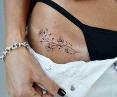 a woman's stomach with a tattoo on her belly and flowers in the middle