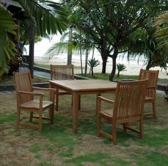 a wooden table and chairs sitting in the grass