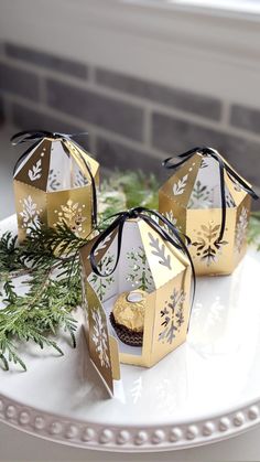 three gold and white boxes on a plate