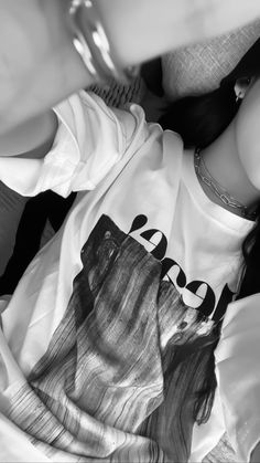 a woman laying on top of a bed next to a white shirt with the word peace printed on it