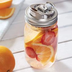 a mason jar filled with sliced oranges and strawberries