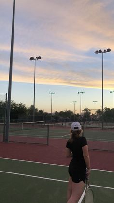 a woman standing on top of a tennis court holding a racquet in her hand