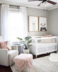 a baby's room with a white crib, pink and gray decor and pictures on the wall