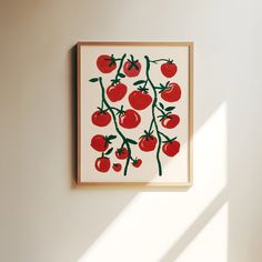 an art piece with tomatoes on it hangs in the corner of a white walled room