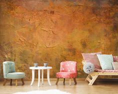 three chairs and a table in front of a wall with an orange pattered background