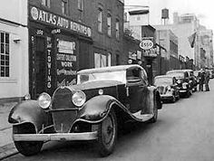 an old car is parked on the side of the street