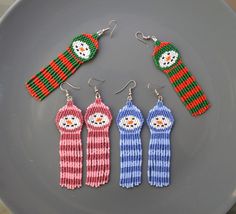 three knitted snowman earrings on a plate