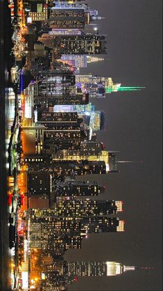 the city skyline is lit up at night with skyscrapers in the foreground and lights on all sides