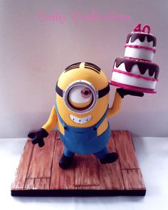 a cake that is sitting on top of a wooden board with a minion holding a piece of cake