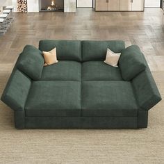 a green couch sitting on top of a hard wood floor