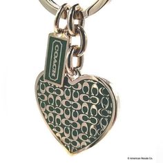 a green and white heart shaped keychain with a tag on it's side