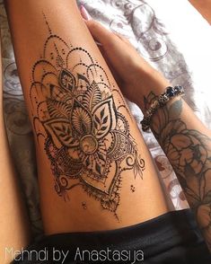 two women with tattoos on their legs are laying next to each other and holding hands