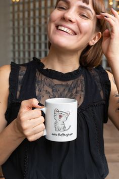 a woman smiles while holding a coffee mug