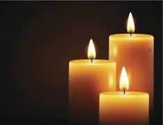 three lit candles on a dark background