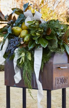 an old mailbox decorated with greenery and fruit