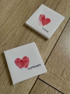 two pieces of cloth with red hearts on them sitting on a wooden floor next to each other