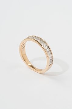 a gold ring with two rows of diamonds on the inside and outside, set against a white background