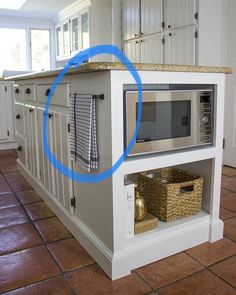 a microwave oven sitting on top of a kitchen counter next to a basket and towel rack