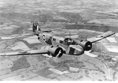 an old airplane flying in the sky over land