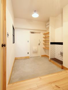 an empty room with shelves and a fire place in the corner on either side of the door