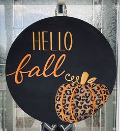 a hello fall sign with leopard print pumpkins