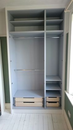 an empty walk in closet with drawers and shelves